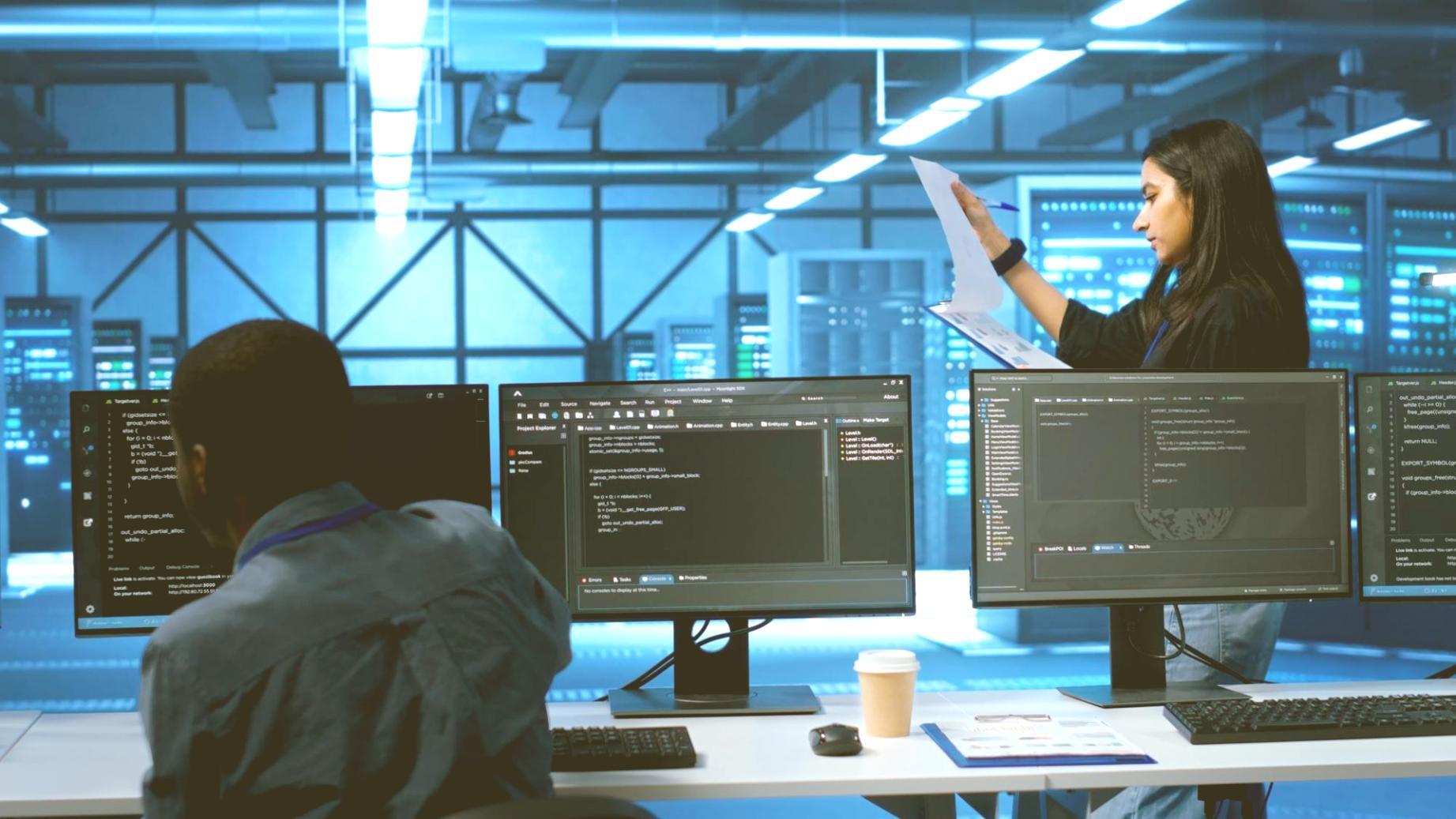 Security professional analyzing network vulnerabilities on multiple monitors
